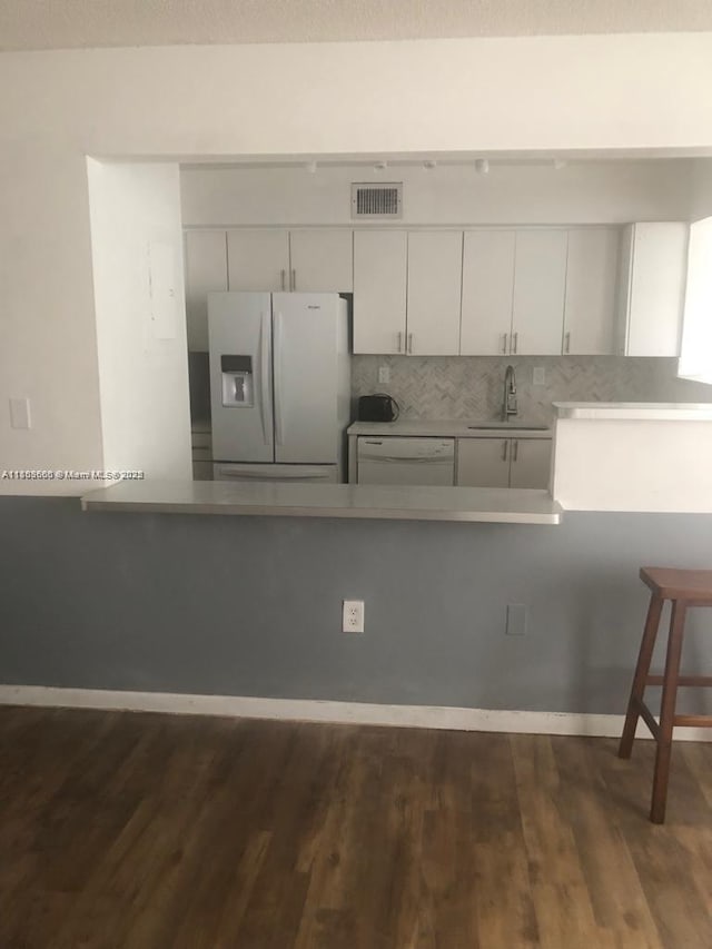 250 180th Dr Unit 108, Sunny Isles Beach, FL 33160 - kitchen featuring white appliances, dark wood-style floors, tasteful backsplash, a sink, and white cabinets