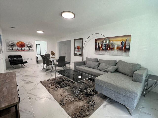 1472 NE 150th St, Miami, FL 33161 - living room with marble look tiles, recessed lighting, and baseboards