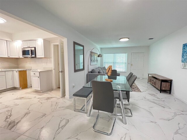 1472 NE 150th St, Miami, FL 33161 - dining area featuring light marble finish floors and baseboards