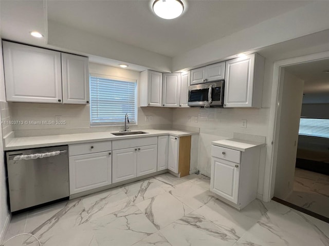 1472 NE 150th St, Miami, FL 33161 - kitchen with appliances with stainless steel finishes, a sink, light marble finish flooring, light countertops, and white cabinetry
