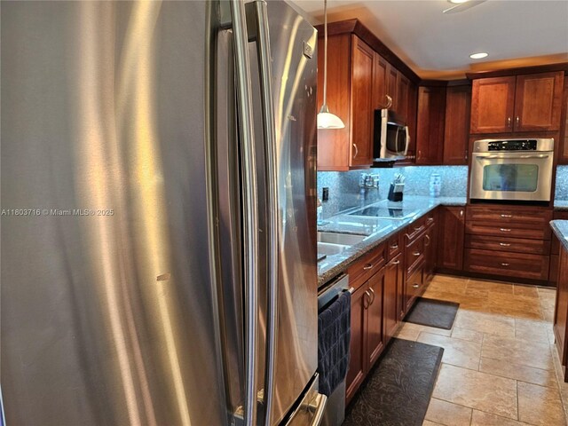 8240 NW 15th St, Pembroke Pines, FL 33024 - kitchen featuring stainless steel appliances, dark stone countertops, stone tile floors, backsplash, and pendant lighting