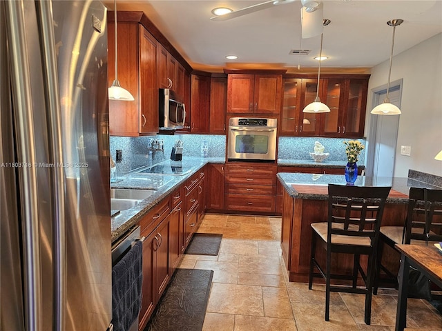 8240 NW 15th St, Pembroke Pines, FL 33024 - kitchen with appliances with stainless steel finishes, tasteful backsplash, dark stone counters, a kitchen breakfast bar, and recessed lighting