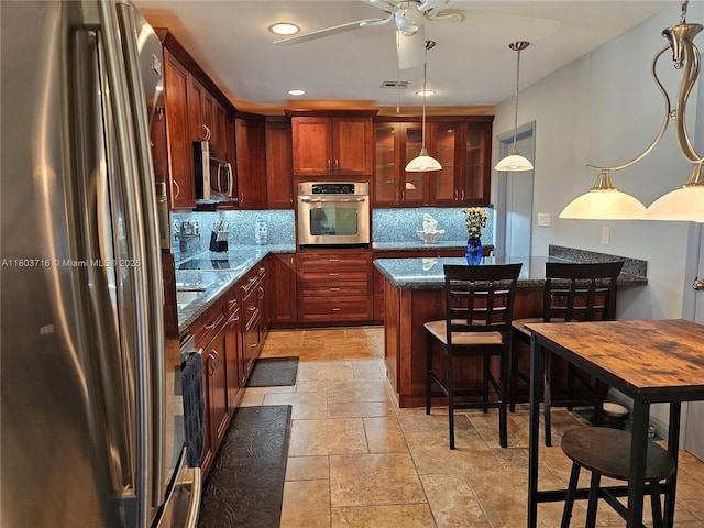 8240 NW 15th St, Pembroke Pines, FL 33024 - kitchen with appliances with stainless steel finishes, decorative backsplash, dark stone counters, stone tile flooring, and pendant lighting