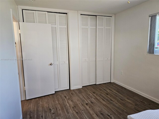 8240 NW 15th St, Pembroke Pines, FL 33024 - unfurnished bedroom with dark wood-style flooring, two closets, and baseboards