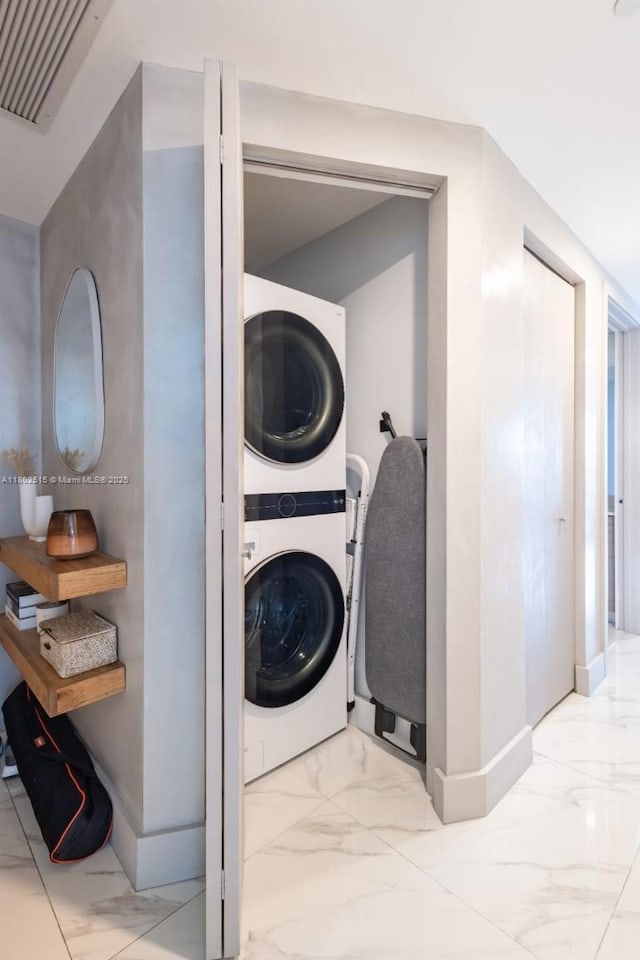 1300 S Miami Ave Unit 2006, Miami, FL 33130 - washroom featuring estacked washer and dryer, light marble finish floors, and baseboards