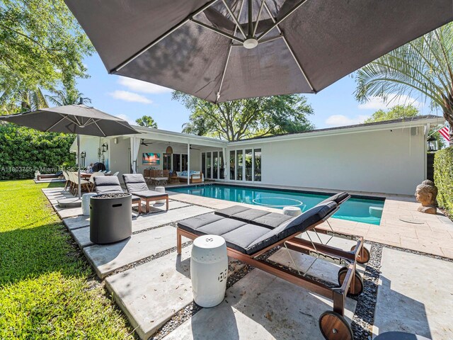 7945 SW 98th Ter, Miami, FL 33156 - outdoor pool with a patio, a fire pit, outdoor dining space, and a ceiling fan
