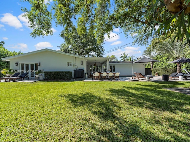 7945 SW 98th Ter, Miami, FL 33156 - rear view of house featuring french doors, a patio area, stucco siding, and a lawn