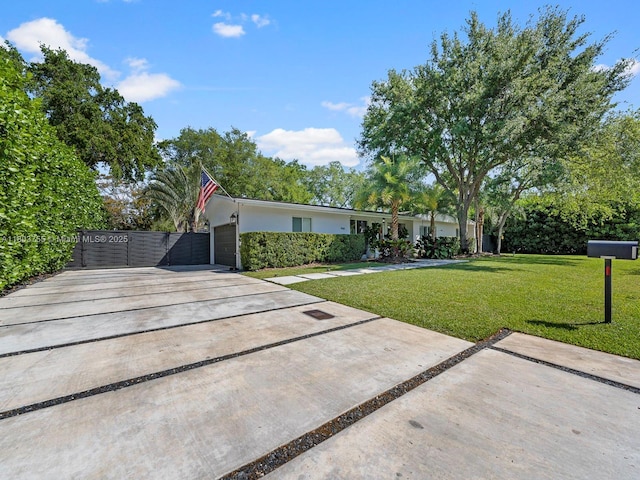 7945 SW 98th Ter, Miami, FL 33156 - view of front of home featuring concrete driveway, a front yard, a garage, stucco siding, and a gate