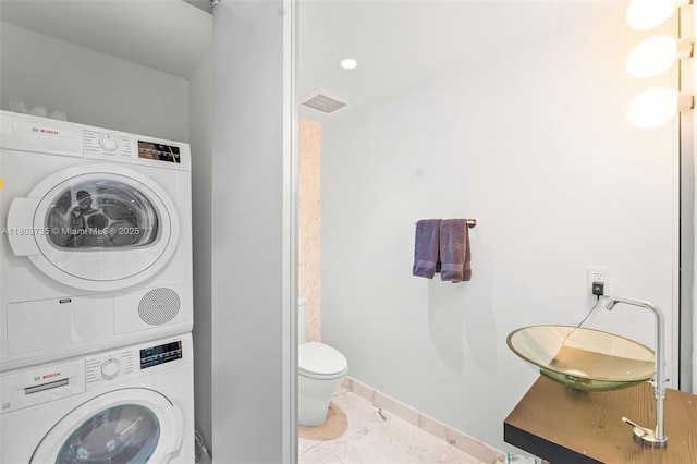 200 Biscayne Boulevard Way Unit 4005, Miami, FL 33131 - bathroom with stacked washer / dryer, toilet, marble finish floors, a sink, and baseboards