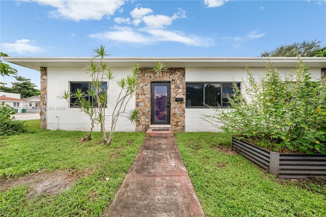 2 NW 47th St, Miami, FL 33127 - view of front of house with a front yard and stone siding