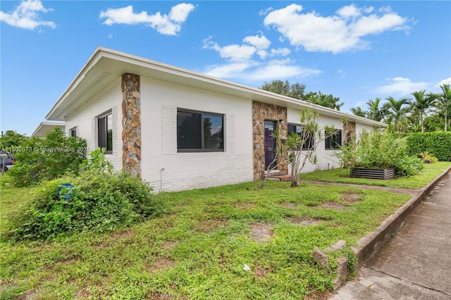 2 NW 47th St, Miami, FL 33127 - ranch-style home with stone siding, a front yard, and stucco siding
