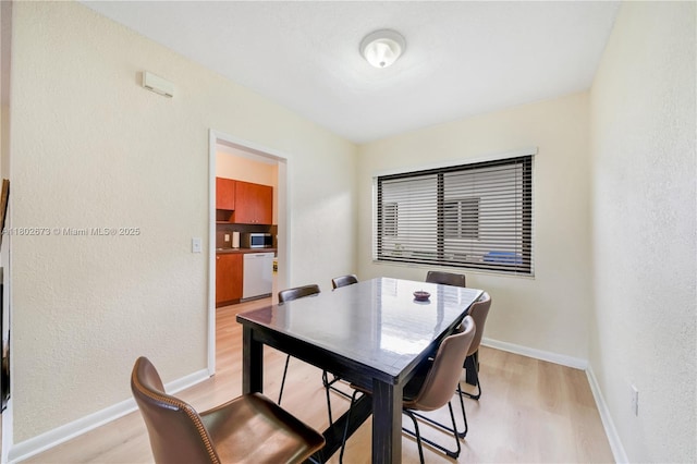 2 NW 47th St, Miami, FL 33127 - dining space featuring light wood-type flooring and a textured wall