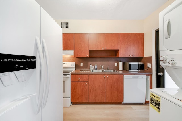 2 NW 47th St, Miami, FL 33127 - kitchen with stacked washer / drying machine, white appliances, decorative backsplash, and light wood-type flooring