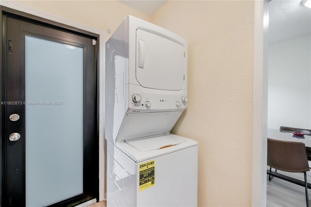 2 NW 47th St, Miami, FL 33127 - laundry area with stacked washing machine and dryer and light wood-type flooring