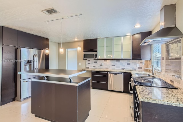 10950 NW 38th Ct, Coral Springs, FL 33065 - kitchen with wall chimney range hood, appliances with stainless steel finishes, track lighting, light tile patterned floors, and backsplash