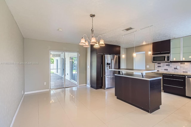 10950 NW 38th Ct, Coral Springs, FL 33065 - kitchen with appliances with stainless steel finishes, backsplash, baseboards, a center island, and modern cabinets