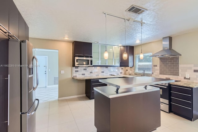 10950 NW 38th Ct, Coral Springs, FL 33065 - kitchen with wall chimney range hood, stainless steel appliances, a textured ceiling, tasteful backsplash, and rail lighting