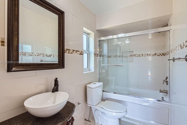 10950 NW 38th Ct, Coral Springs, FL 33065 - bathroom featuring a sink, bath / shower combo with glass door, and toilet