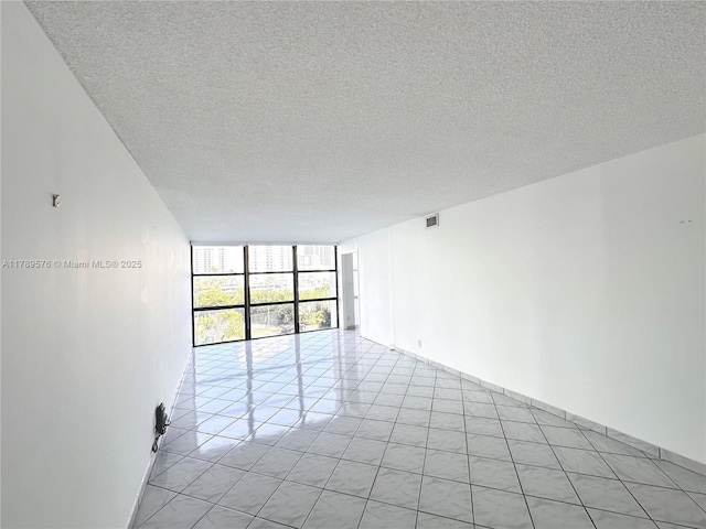 1000 Parkview Dr Unit 424, Hallandale Beach, FL 33009 - unfurnished room featuring floor to ceiling windows, a textured ceiling, and light tile patterned floors