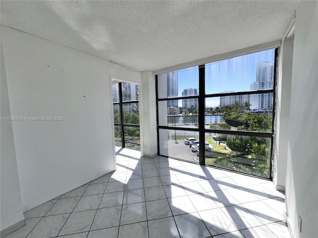 1000 Parkview Dr Unit 424, Hallandale Beach, FL 33009 - spare room featuring floor to ceiling windows, a water view, a view of city, a textured ceiling, and light tile patterned flooring