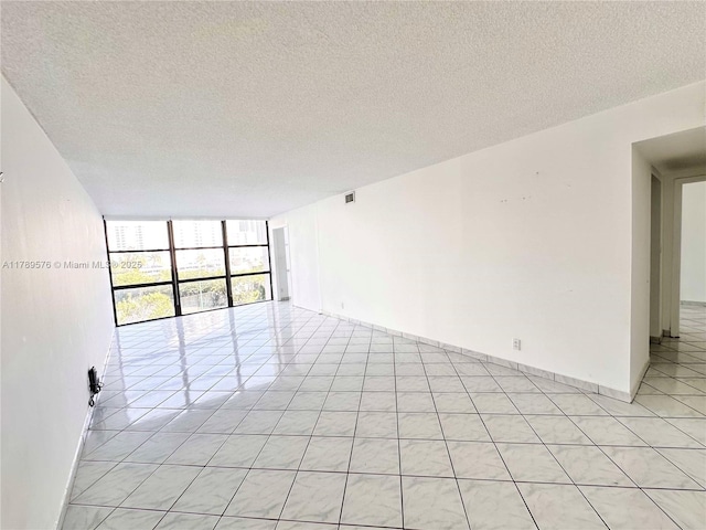 1000 Parkview Dr Unit 424, Hallandale Beach, FL 33009 - spare room featuring expansive windows, a textured ceiling, and light tile patterned floors