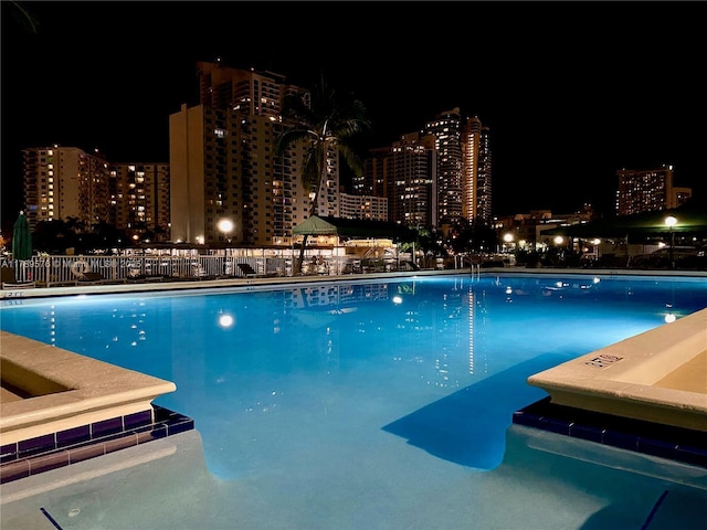 1000 Parkview Dr Unit 424, Hallandale Beach, FL 33009 - pool at night featuring a view of city lights and a community pool