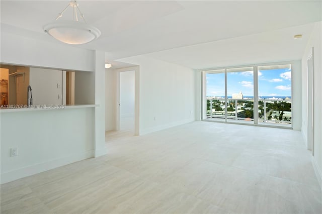 650 W Ave Unit 1404, Miami Beach, FL 33139 - unfurnished living room with a wall of windows and baseboards
