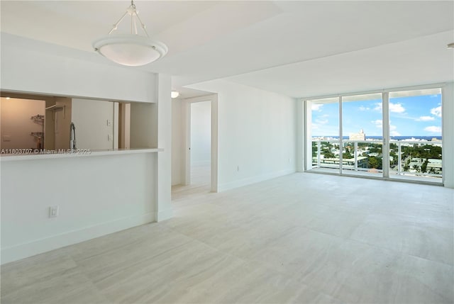 650 W Ave Unit 1404, Miami Beach, FL 33139 - unfurnished living room with a wall of windows and baseboards
