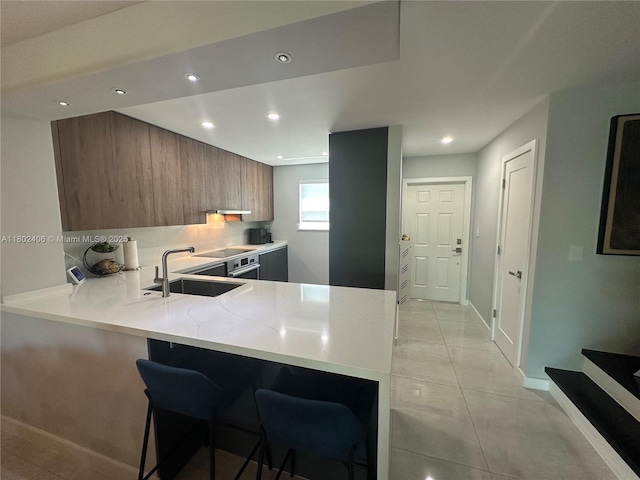 8443 SW 137th Ave Unit 8443, Miami, FL 33183 - kitchen with a sink, brown cabinets, modern cabinets, a peninsula, and a kitchen breakfast bar