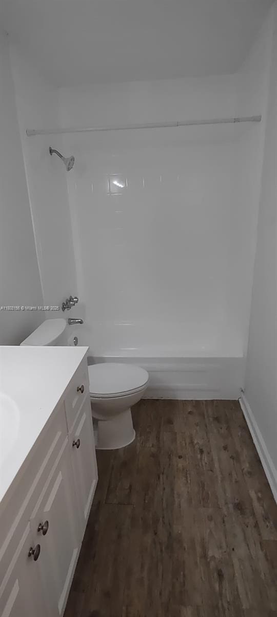full bath featuring toilet, vanity, shower / bathtub combination, and wood finished floors