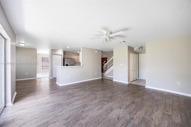 16421 SW 103rd Ter, Miami, FL 33196 - unfurnished living room featuring a ceiling fan, baseboards, wood finished floors, and stairs