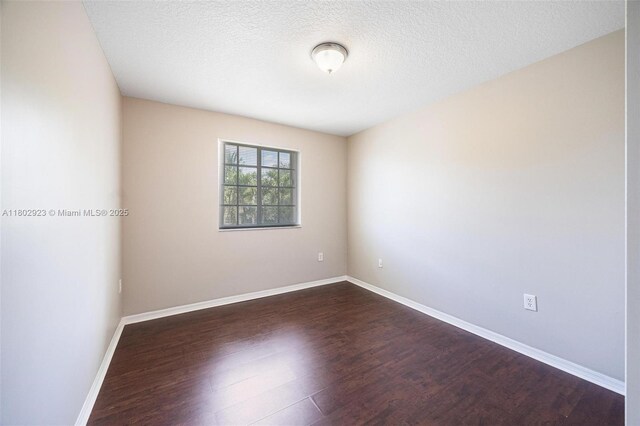 16421 SW 103rd Ter, Miami, FL 33196 - empty room featuring dark wood-style flooring, baseboards, and a textured ceiling