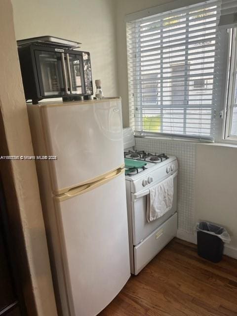741 15th St Unit 8, Miami Beach, FL 33139 - kitchen featuring white gas stove, fridge, wood finished floors, and black microwave