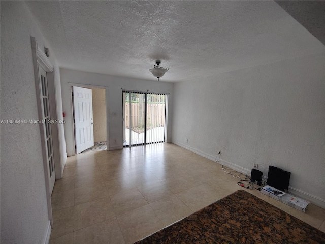 616 Executive Center Dr Unit 107, West Palm Beach, FL 33401 - spare room featuring a textured ceiling, baseboards, and light tile patterned floors