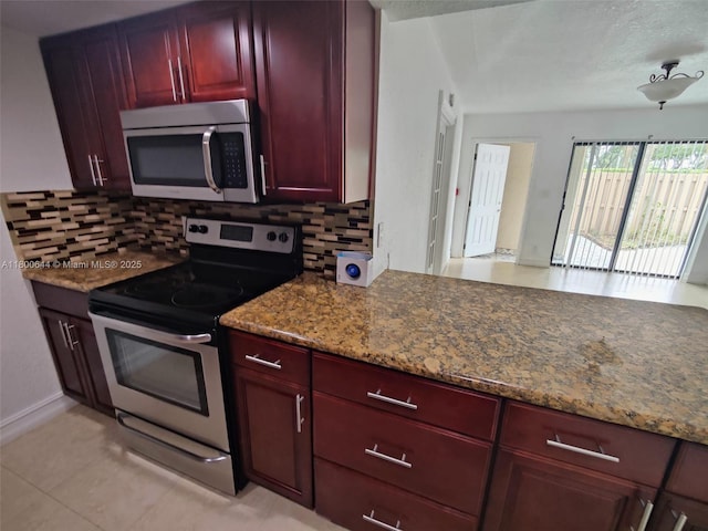 616 Executive Center Dr Unit 107, West Palm Beach, FL 33401 - kitchen featuring stainless steel appliances, dark brown cabinets, decorative backsplash, light stone counters, and a textured ceiling