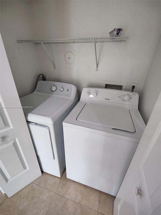 616 Executive Center Dr Unit 107, West Palm Beach, FL 33401 - laundry area featuring washer and dryer and light tile patterned floors