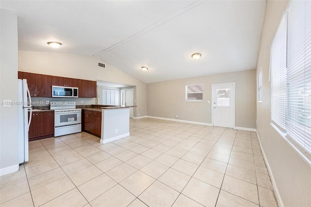 19735 NE 12th Ave, Miami, FL 33179 - kitchen featuring white appliances, open floor plan, vaulted ceiling, a peninsula, and baseboards