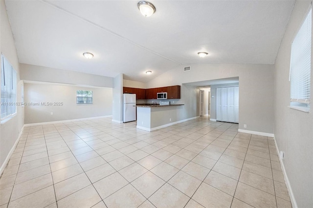 19735 NE 12th Ave, Miami, FL 33179 - unfurnished living room featuring lofted ceiling, light tile patterned floors, and baseboards