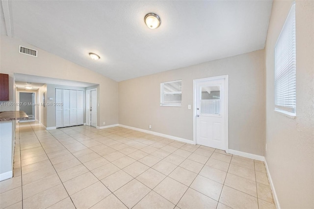 19735 NE 12th Ave, Miami, FL 33179 - unfurnished living room with vaulted ceiling, light tile patterned floors, and baseboards