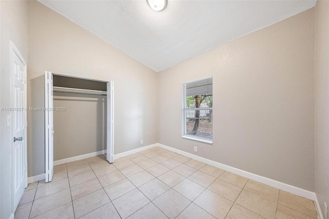 19735 NE 12th Ave, Miami, FL 33179 - unfurnished bedroom with vaulted ceiling, light tile patterned floors, a closet, and baseboards