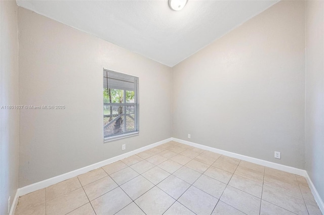 19735 NE 12th Ave, Miami, FL 33179 - spare room with light tile patterned floors, baseboards, and vaulted ceiling