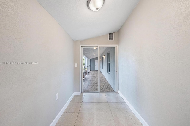 19735 NE 12th Ave, Miami, FL 33179 - hall with vaulted ceiling, baseboards, light tile patterned floors, and a textured wall