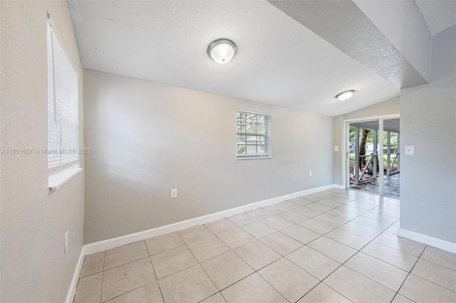 19735 NE 12th Ave, Miami, FL 33179 - unfurnished room featuring light tile patterned flooring, a textured ceiling, baseboards, and vaulted ceiling