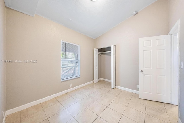 19735 NE 12th Ave, Miami, FL 33179 - unfurnished bedroom featuring lofted ceiling, light tile patterned flooring, a closet, and baseboards