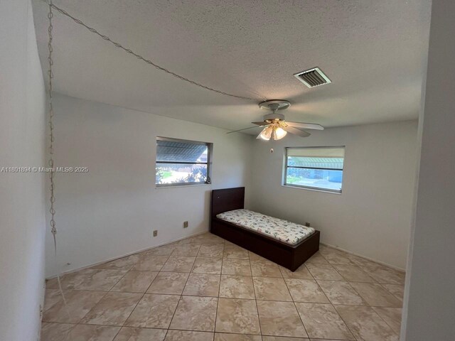 1130 NW 67th Ave, Margate, FL 33063 - bedroom featuring a textured ceiling, light tile patterned floors, and ceiling fan