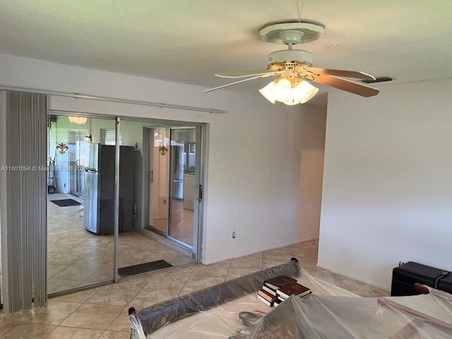 1130 NW 67th Ave, Margate, FL 33063 - bedroom featuring freestanding refrigerator, light tile patterned floors, a textured ceiling, ceiling fan, and a closet