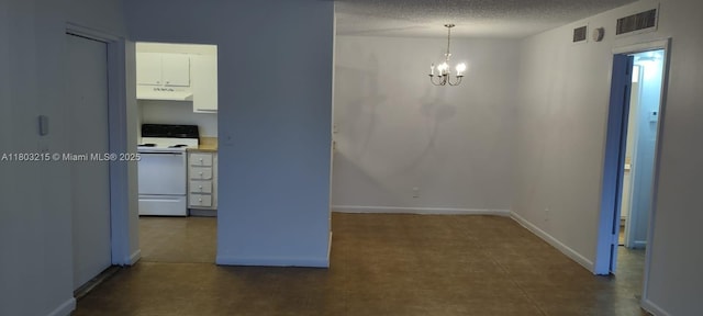 unfurnished dining area featuring a chandelier, a textured ceiling, and baseboards