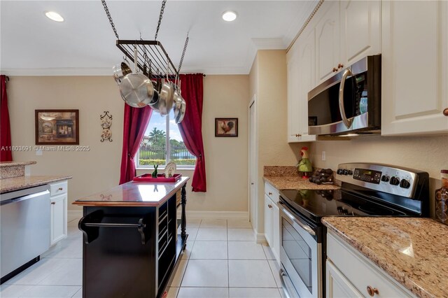 9248 SW 209th Ter, Cutler Bay, FL 33189 - kitchen with appliances with stainless steel finishes, ornamental molding, white cabinets, light stone counters, and light tile patterned flooring