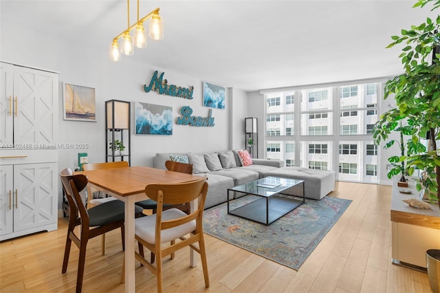 1228 W Ave Unit 704, Miami Beach, FL 33139 - living area featuring light wood-style flooring and a wall of windows