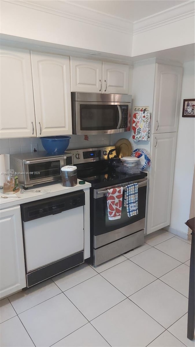 1400 Saint Charles Pl Unit L4, Pembroke Pines, FL 33026 - kitchen featuring appliances with stainless steel finishes, crown molding, white cabinets, light tile patterned flooring, and light countertops